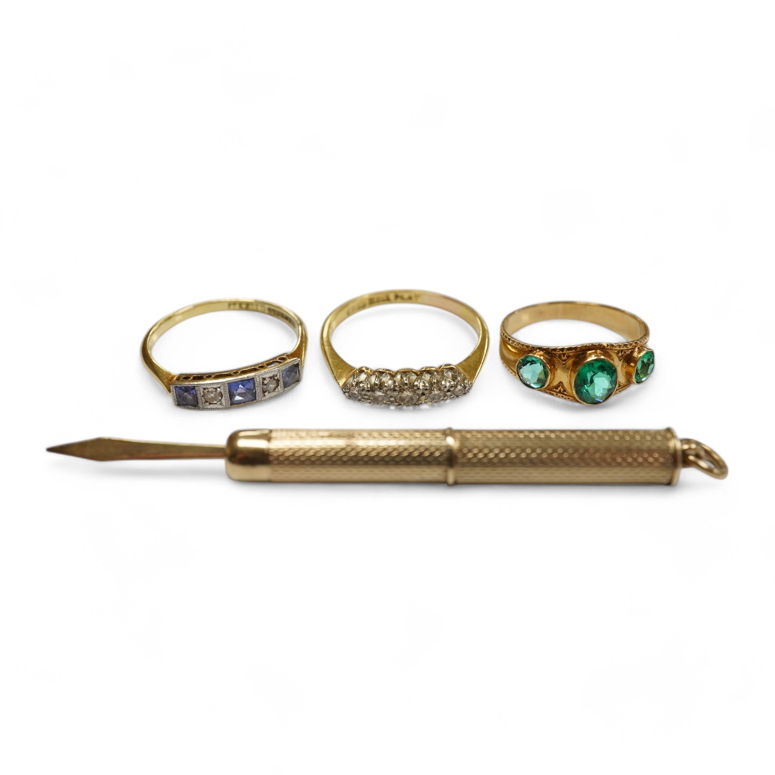 A group of three rings and a gold toothpick